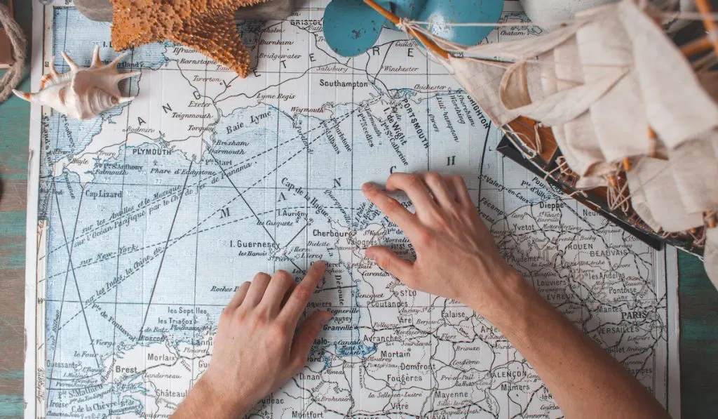 Man's hand on map pointing on his next destination